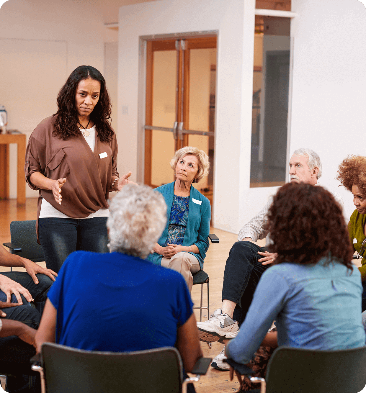 Woman leading a group discussion in a casual setting.