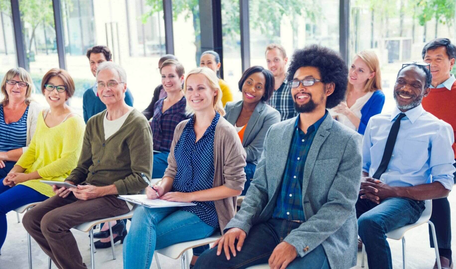 A diverse group attentively listening in a classroom or seminar setting.