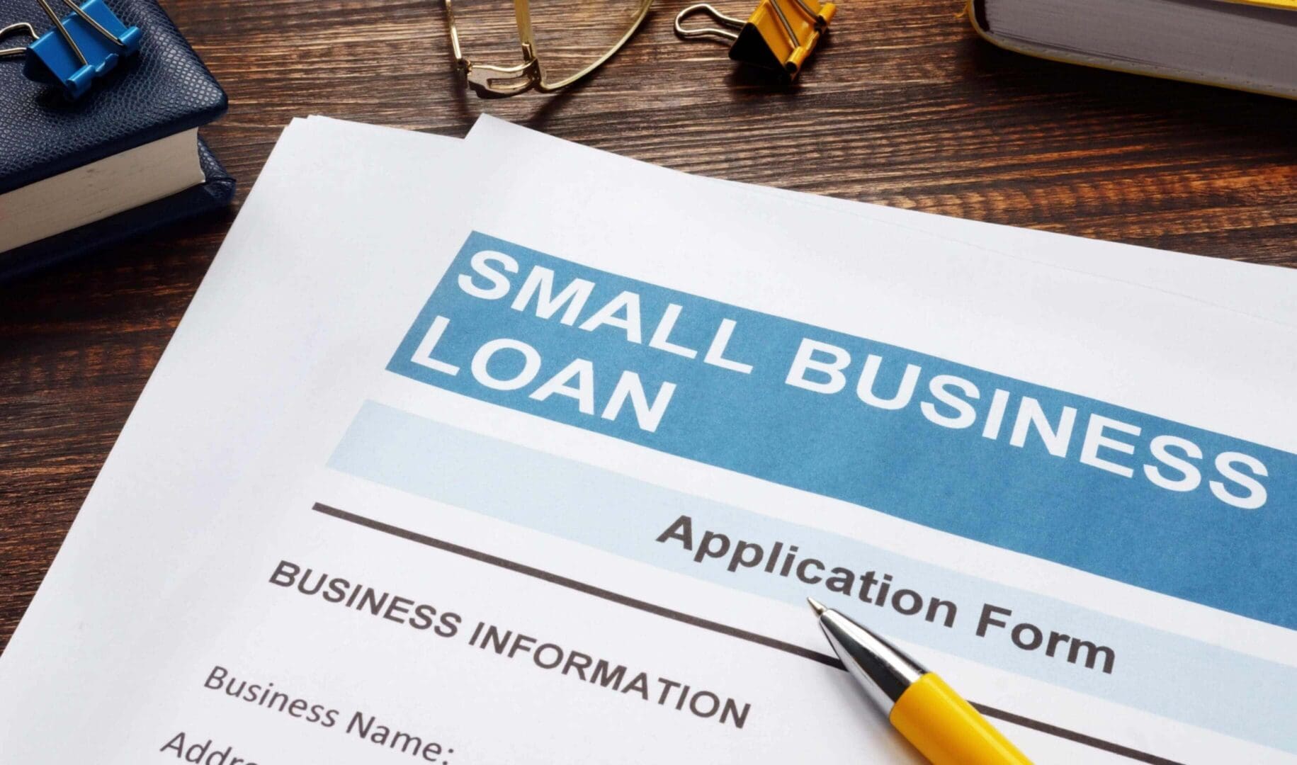 Small business loan application form on a desk with a pen.