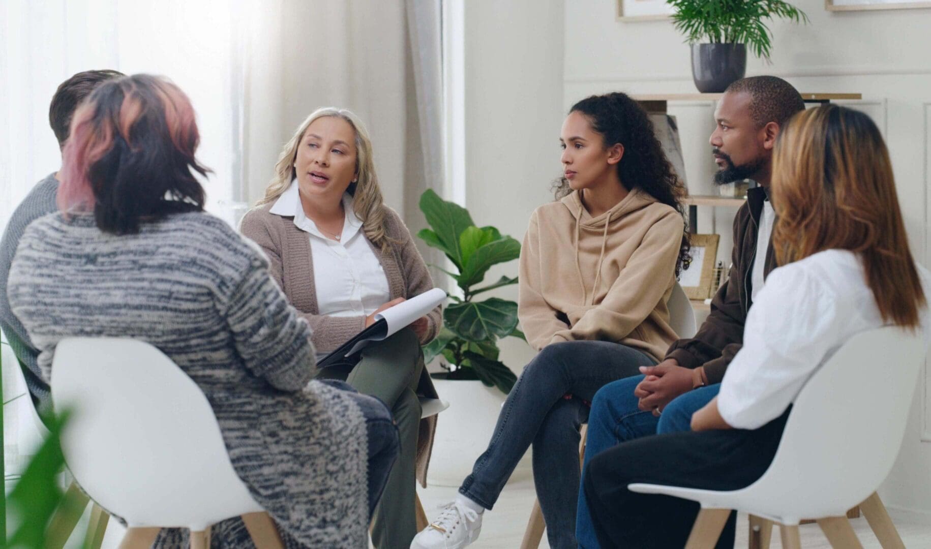 A group engaged in a supportive group therapy session indoors.
